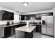 Well-lit kitchen with stainless steel appliances, dark cabinets, and a functional center island at 4135 Benicia Ln, Indianapolis, IN 46235