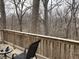 Outdoor deck featuring a bistro table and chair with a forested view from the backyard at 4214 Woodsage Trce, Indianapolis, IN 46237
