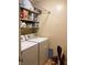 Practical laundry area with a washer and dryer, complemented by shelving for storage of detergents and essentials at 4214 Woodsage Trce, Indianapolis, IN 46237