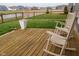 Inviting wooden back deck with rocking chairs, perfect for relaxing and enjoying the backyard view at 462 N Crystal Dr, Fortville, IN 46040