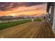 Inviting wooden back deck with rocking chairs and a stunning sunset view, perfect for relaxing outside at 462 N Crystal Dr, Fortville, IN 46040