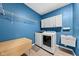 Blue laundry room featuring a sink, folding table, and modern washer and dryer at 462 N Crystal Dr, Fortville, IN 46040