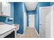 Blue laundry room featuring a sink, cabinet space, and access to other rooms at 462 N Crystal Dr, Fortville, IN 46040