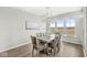 Bright dining room with wood table, upholstered chairs, modern light fixture, and large windows at 4763 Denton Dr, Zionsville, IN 46077