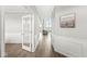 Bright hallway featuring hardwood floors, white wainscoting, and an open doorway leading to the living area at 4763 Denton Dr, Zionsville, IN 46077