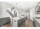 Spacious kitchen with gray cabinets, stainless steel appliances, island with sink and seating, and wood flooring at 4763 Denton Dr, Zionsville, IN 46077