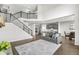 Open-concept living space featuring high ceilings, staircase, and view into kitchen with stainless steel appliances at 4763 Denton Dr, Zionsville, IN 46077
