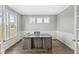 Bright home office with large windows, hardwood floors, white wainscoting, and a modern desk at 4763 Denton Dr, Zionsville, IN 46077