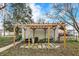 A backyard featuring a shaded pergola, seating area, and well-maintained landscaping at 4933 Ford St, Indianapolis, IN 46224