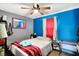 Bedroom with blue accent wall and bright window at 4933 Ford St, Indianapolis, IN 46224