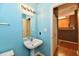 Bright bathroom featuring a pedestal sink, modern lighting, and blue walls at 4951 Tuscany Ln, Indianapolis, IN 46254