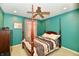 Cozy bedroom with an inviting four-poster bed, ceiling fan, and bright turquoise walls at 4951 Tuscany Ln, Indianapolis, IN 46254