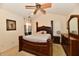 Bedroom featuring a dark wood frame bed, ceiling fan, and decorative art at 4951 Tuscany Ln, Indianapolis, IN 46254