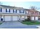 Charming townhome exterior featuring an attached garage, a well-manicured lawn, and tidy landscaping at 4951 Tuscany Ln, Indianapolis, IN 46254