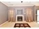 Living room with a fireplace, neutral walls and curtains, and brown geometric rug at 4951 Tuscany Ln, Indianapolis, IN 46254