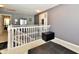 Upstairs hallway featuring gray walls, carpeting, a modern fixture and an open railing at 4951 Tuscany Ln, Indianapolis, IN 46254