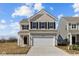 Charming two-story home with beige siding, black shutters, and a two-car garage at 5208 Rolling Meadow Blvd, Indianapolis, IN 46237