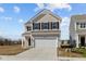 Charming two-story home with beige siding, black shutters, and a two-car garage at 5208 Rolling Meadow Blvd, Indianapolis, IN 46237