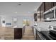 Open-concept kitchen with island, stainless appliances, and view to living area at 5208 Rolling Meadow Blvd, Indianapolis, IN 46237