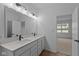 Bathroom boasts a double vanity, quartz countertop, large mirror, and wood-look flooring at 5211 Rolling Meadow Blvd, Indianapolis, IN 46237