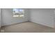 Spacious bedroom with neutral carpet, white walls, and a large window for ample natural light at 5211 Rolling Meadow Blvd, Indianapolis, IN 46237