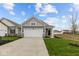 Charming gray home with a two-car garage and well-manicured lawn at 5211 Rolling Meadow Blvd, Indianapolis, IN 46237