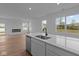 Contemporary kitchen featuring white cabinetry, quartz countertops, and an island sink at 5211 Rolling Meadow Blvd, Indianapolis, IN 46237
