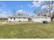 Wide backyard features a detached garage, grassy area, and a clear view of the bright blue sky at 5225 S Linwood Ave, Indianapolis, IN 46237