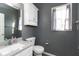 Cozy bathroom with gray walls, a storage cabinet, toilet, and sink with solid surface counter top at 5607 Regency Dr, Columbus, IN 47203