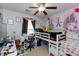 Bedroom featuring a raised bed, desk area, ceiling fan, and bright decor at 5607 Regency Dr, Columbus, IN 47203