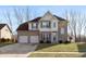 Two-story home featuring a well-manicured lawn, attached two car garage and neutral brick and tan siding at 5607 Regency Dr, Columbus, IN 47203