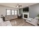 Comfortable living room with a fireplace, hardwood flooring, ceiling fan, and large windows at 5607 Regency Dr, Columbus, IN 47203