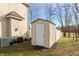 Backyard storage shed with white door, nestled next to the home and white privacy fence, on a green lawn at 5607 Regency Dr, Columbus, IN 47203