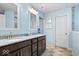 Light blue bathroom featuring double sinks with granite countertop and dark cabinetry at 5658 Pecan Ct, Noblesville, IN 46062