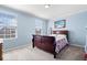 Cozy blue bedroom with two windows and a dark wood bed frame, bright and airy at 5658 Pecan Ct, Noblesville, IN 46062