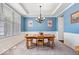 Bright dining room with blue walls, chandelier, wainscoting, and a large window at 5658 Pecan Ct, Noblesville, IN 46062