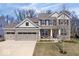Charming two-story home boasts a manicured lawn, stone accents, and attached two car garage at 5658 Pecan Ct, Noblesville, IN 46062