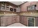 Basement kitchenette boasts rich wood cabinets, granite countertops, wine storage, and modern appliances at 5658 Pecan Ct, Noblesville, IN 46062