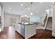 Open floorplan with large island, stainless appliances, hardwood floors, and adjacent Gathering room at 5658 Pecan Ct, Noblesville, IN 46062