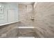 Modern tiled shower with a built-in bench, a glass partition, and a sleek shower head at 5658 Pecan Ct, Noblesville, IN 46062