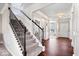 Staircase featuring decorative black iron spindles, carpeted steps, and hardwood flooring at 5658 Pecan Ct, Noblesville, IN 46062