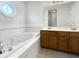 Bright bathroom featuring a soaking tub, vanity with double sinks and octagonal window at 603 Raintree Dr, Avon, IN 46123