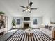 Bright living room features a fireplace, ceiling fan, and stylish black and white striped rug at 603 Raintree Dr, Avon, IN 46123