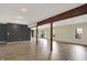 Large basement with wood-look flooring, dark accent wall, support beams, and ample natural light at 7023 Mustang Ct, Martinsville, IN 46151
