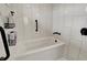 Modern bathtub with matte black hardware and white subway tile, alongside a storage rack with essential bath products at 7023 Mustang Ct, Martinsville, IN 46151