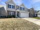 Charming two-story home with gray siding, stone accents, well-manicured lawn, and attached garage at 733 Keepsake Run, Greenwood, IN 46143