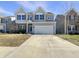 Inviting two-story home featuring gray siding, stone accents, a well-maintained lawn, and an attached garage at 733 Keepsake Run, Greenwood, IN 46143