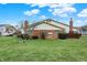 Backyard featuring a well-maintained lawn, mature landscaping, and a brick exterior at 7607 Farm View E Cir, Indianapolis, IN 46256