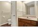 Bathroom featuring a wood vanity, a decorative mirror, and a toilet at 7607 Farm View E Cir, Indianapolis, IN 46256