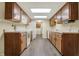 Kitchen with wood cabinets, white appliances, gray flooring, and a view of the laundry area at 7607 Farm View E Cir, Indianapolis, IN 46256